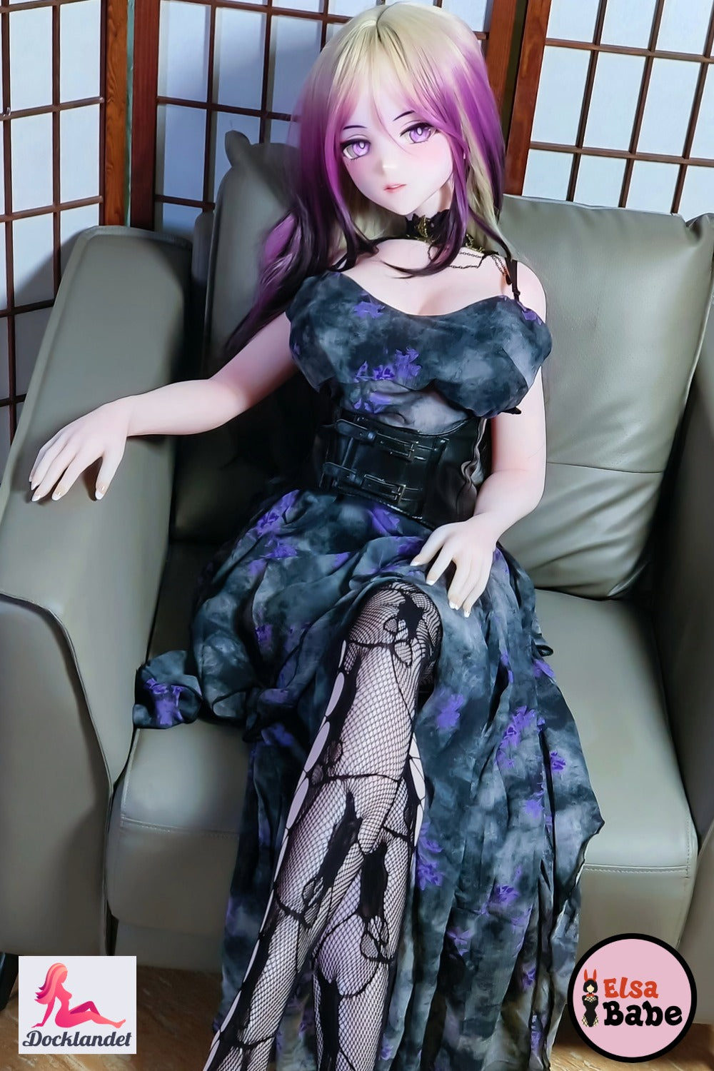 Elsa Babe Kitano Mina Anime silikoninė lėlė, sėdinti fotelyje su juodos ir violetinės spalvos suknele, platininiu silikonu ir skaidriu roko karalienės stiliumi.