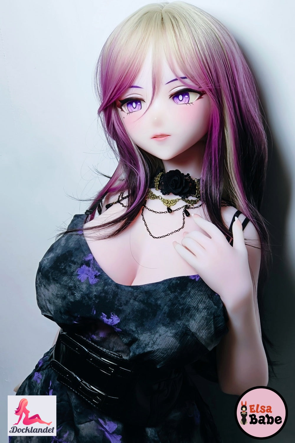 Elsa Babe Kitano Mina Anime silikoninė lėlė, sėdinti fotelyje su juodos ir violetinės spalvos suknele, platininiu silikonu ir skaidriu roko karalienės stiliumi.
